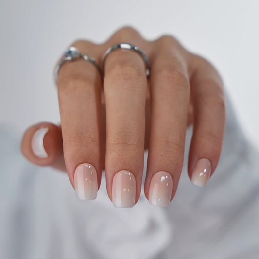 Hand with gradient nail polish on a neutral background