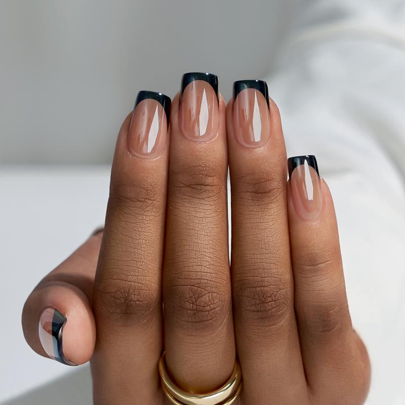 Hand with black and clear nail polish on a neutral background