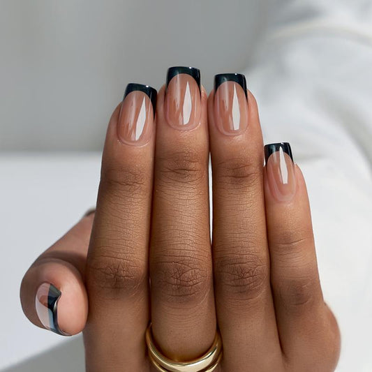 Hand with black and clear nail polish on a neutral background