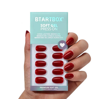 Hand holding a package of BTARTBOX soft gel press-on nails with red nails.