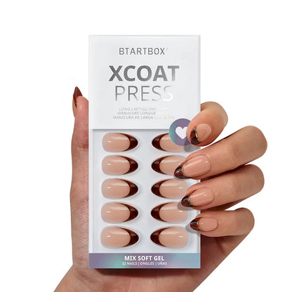 Hand holding a package of BTARTBOX XCOAT PRESS nail extensions with a white background