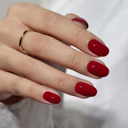 Hand with red nail polish on a blurred background