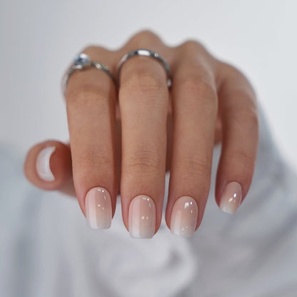 Hand with gradient nail polish on a neutral background