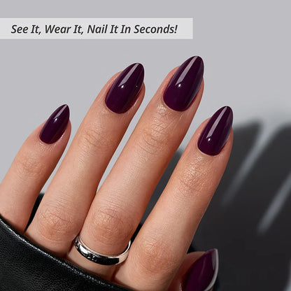 Hand with dark purple nail polish on a gray background