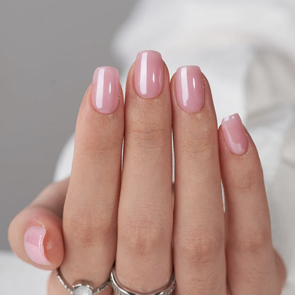 Close-up of a hand with pink nail polish on a neutral background