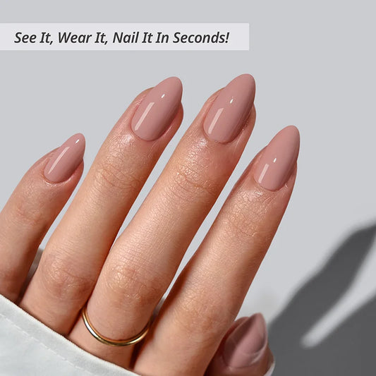 Hand with pink nail polish on a light gray background