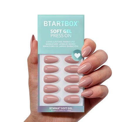 Hand holding a package of BTSTARTBOX soft gel press-ons with pink nails.