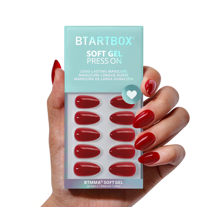 Hand holding a BTARTBOX soft gel press-on nail set with red nails on a white background