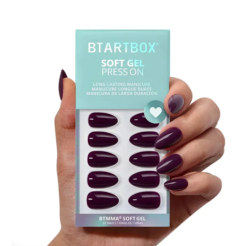 Hand holding a package of BTSTARTBOX soft gel press-ons with purple nails.
