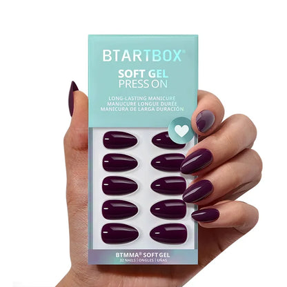 Hand holding a package of BTSTARTBOX soft gel press-ons with purple nails.
